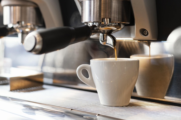 close-up-machine-pouring-coffee-cup_23-2148892834.jpg